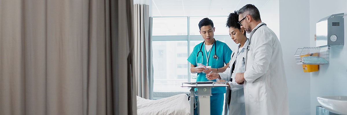 three clinicians gather in a hospital room